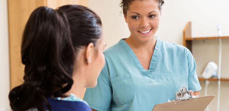 A female medical assistant speaks with a patient 