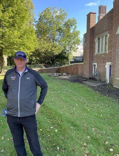 A groundskeeper stands near Hamilton Hall