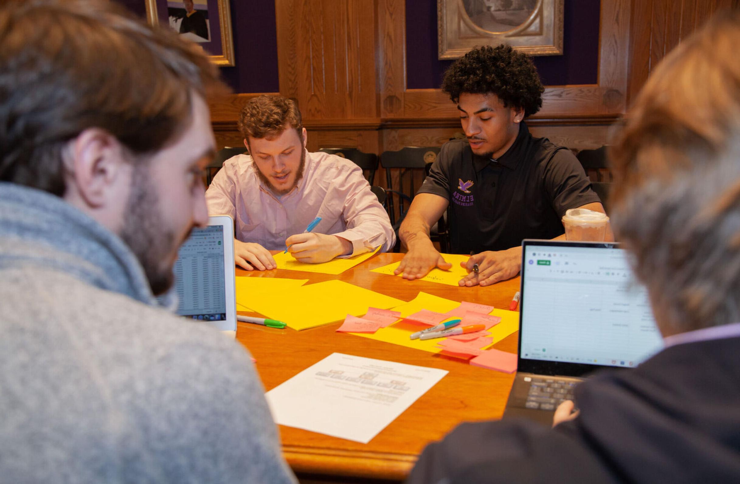 Students write on paper together in an information technology class